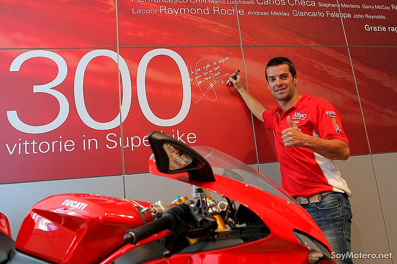 Carlos Checa firmando el mural conmemorativo de 300 victorias SBk en la fábrica de Ducati