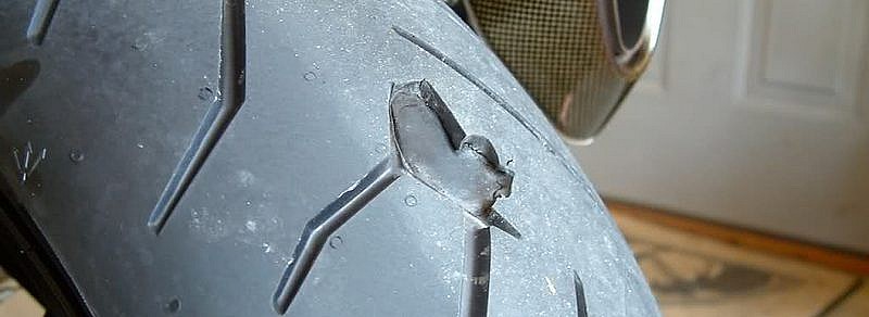 Neumático de moto dañado (goma arrancada)