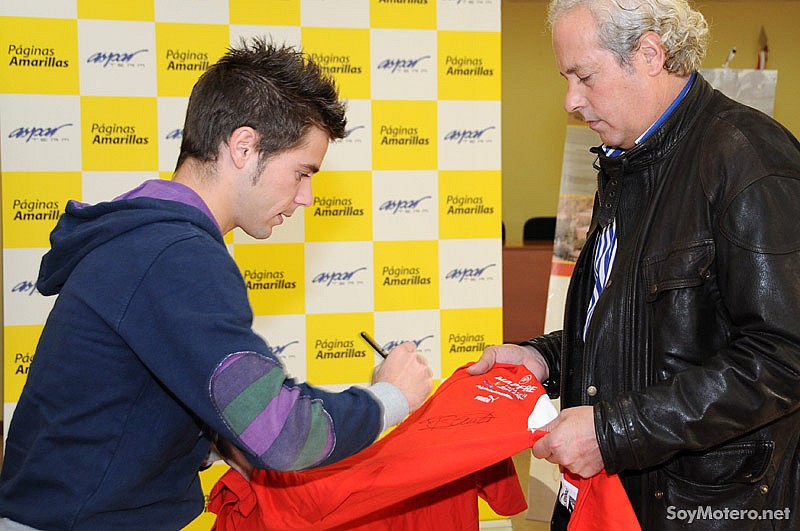 Álvaro Bautista firma camisas de Aspar Team ayudado por su manager Armando Guerrero