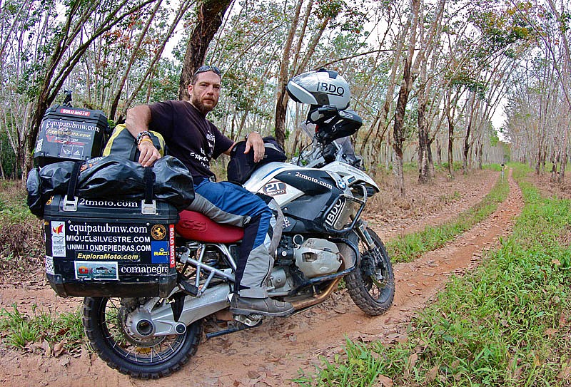 Miquel Silvestre, con su moto BMW en un típico bosque de caucho de Malasia
