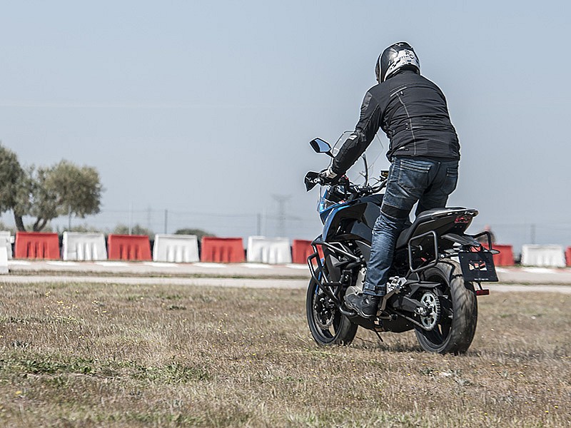 Vista por detrás de la CFMOTO 650 MT, en acción sobre la hierba.