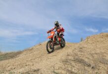 Usuario con su moto de enduro en zona de campo