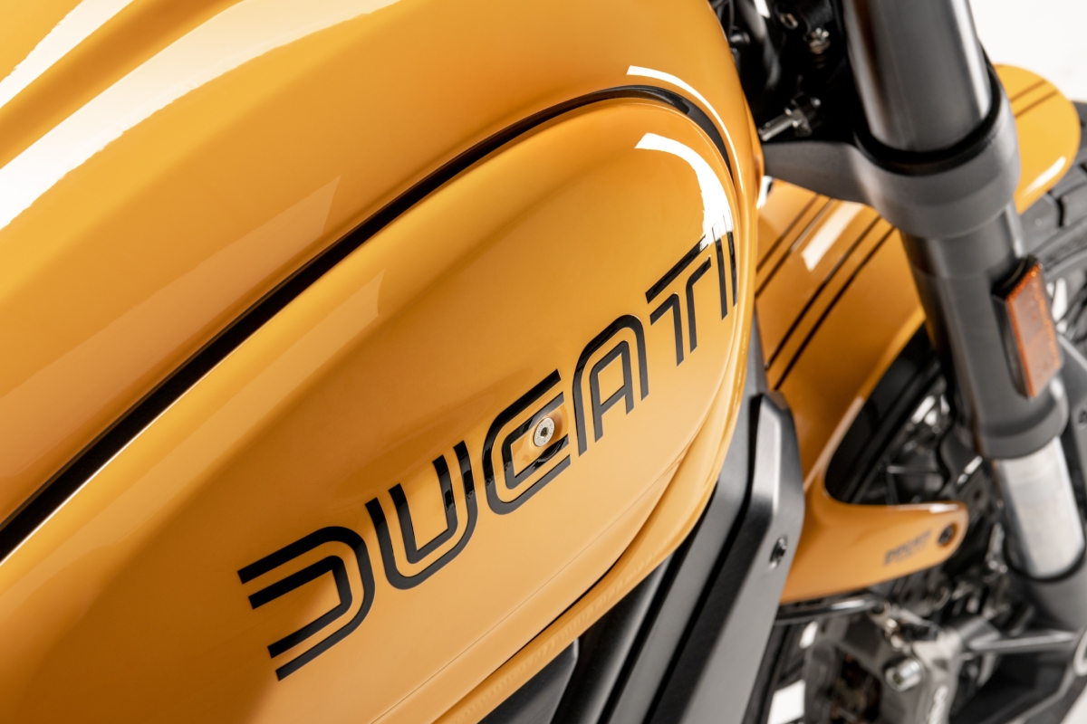 Detalle del depósito de la nueva Ducati Scrambler 1100 Tribute PRO con el logo diseñado por Giugiaro y el nuevo color Amarillo Ocre