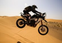 Moto saltando una duna en el desierto