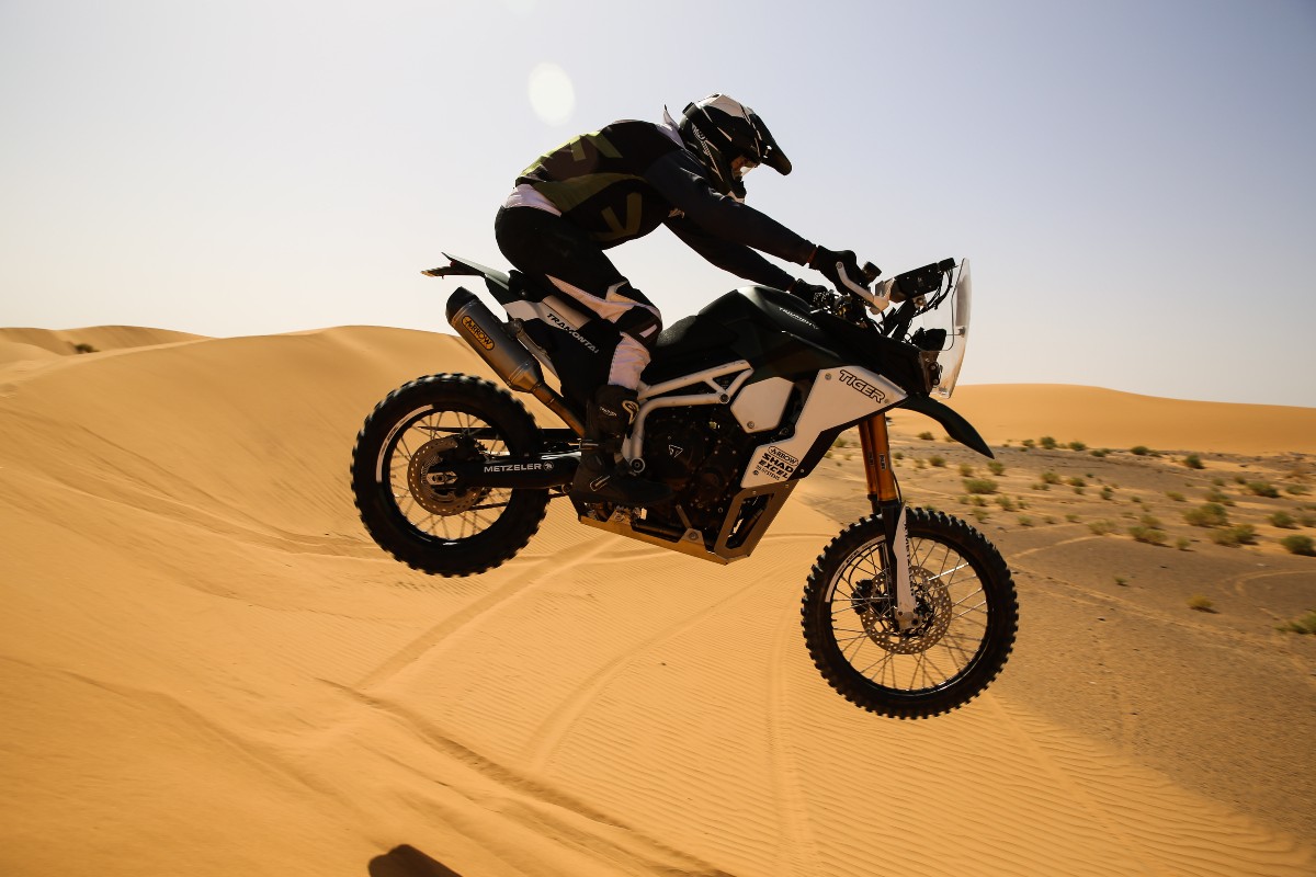 Moto saltando una duna en el desierto