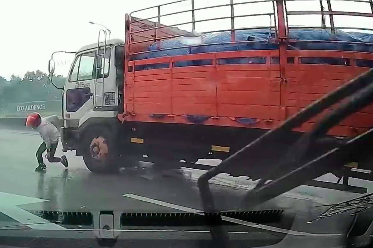 El momento del milagro: este motero se salvó de que le atropellara un camión tras caerse con su moto en la India