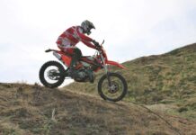 Usuario con su moto de enduro en zona de campo