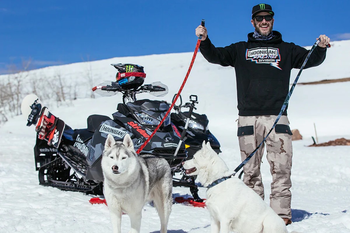 Ken Block en la nieve con una de sus motos y sus perros