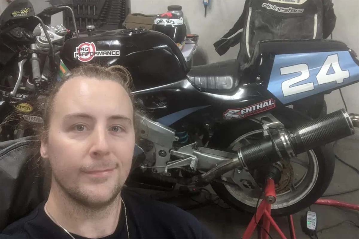 Harley junto a su moto durante una carrera de 2022