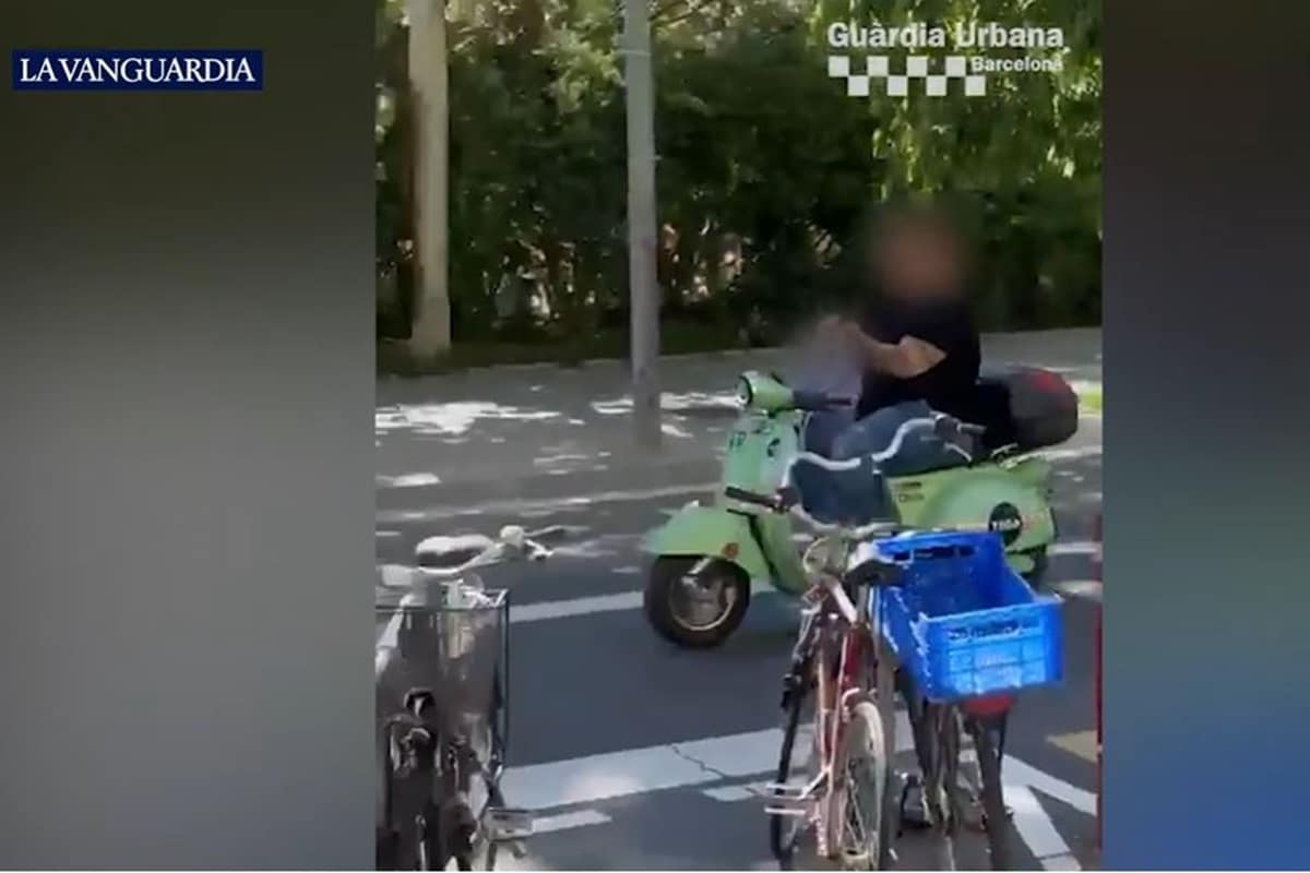 Temerario a la vista: Sin casco, mirando el móvil y ¡con una niña pilotando el scooter donde iban subidos ambos!